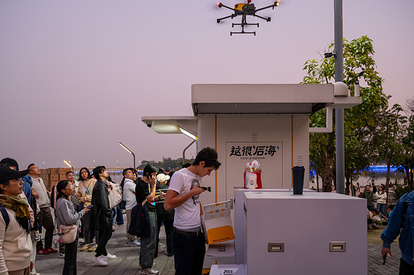 在深圳，外國游客體驗(yàn)無人機(jī)外賣送餐。