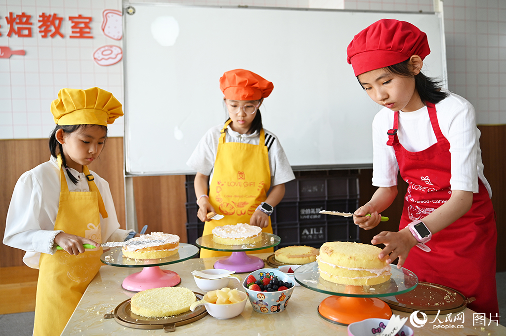 2026年5月30日，在甘肅蘭州一家蛋糕店內(nèi)，孩子們體驗(yàn)蛋糕烘焙。人民網(wǎng) 席娟娟攝