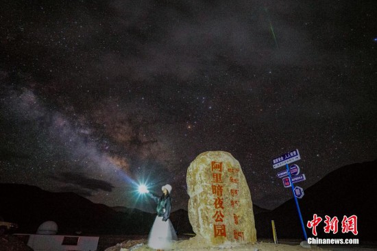 圖為6月20日晚，游客“打卡”西藏阿里暗夜公園，天上是銀河與流星（右上角）。曹枝清 攝