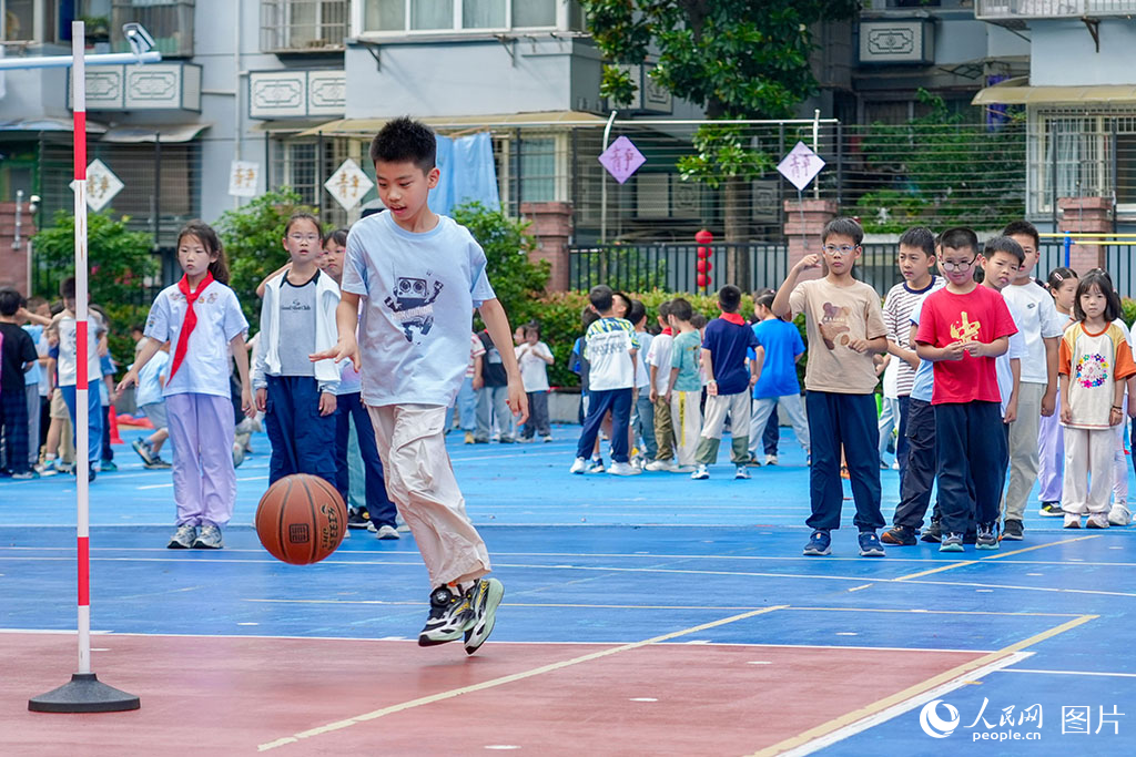 2026年5月27日，浙江杭州長(zhǎng)壽橋小學(xué)的孩子們?cè)诓賵?chǎng)上打籃球。奔跑、傳球、投籃，笑聲與腳步聲交織成一片。人民網(wǎng)記者 郭揚(yáng)攝