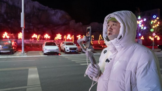 在吉林市阿什哈達(dá)霧凇觀景帶，霧凇播報員正在直播。新華社記者 李典 攝