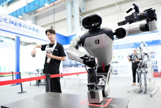 9月5日，在沈陽(yáng)的2025全球工業(yè)互聯(lián)網(wǎng)大會(huì)的展覽區(qū)現(xiàn)場(chǎng)，中國(guó)科學(xué)院沈陽(yáng)自動(dòng)化研究所的機(jī)器人工程師在調(diào)試具身智能操作系統(tǒng)。新華社記者 李鋼 攝