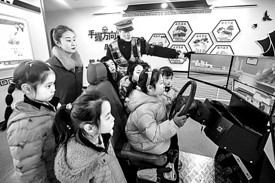 山東省榮成市公安局道路交通安全宣傳教育基地，交警帶領(lǐng)小學(xué)生現(xiàn)場體驗(yàn)?zāi)M駕駛。新華社發(fā)