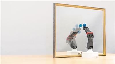  圖為機器人觀察自己在鏡子中的倒影，學習自身的形態(tài)和運動學，實現(xiàn)自主模擬。圖片來源：美國哥倫比亞大學