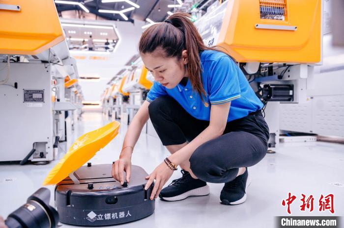 圖為員工在調(diào)試AGV搬運機器人?！±钅宪?攝