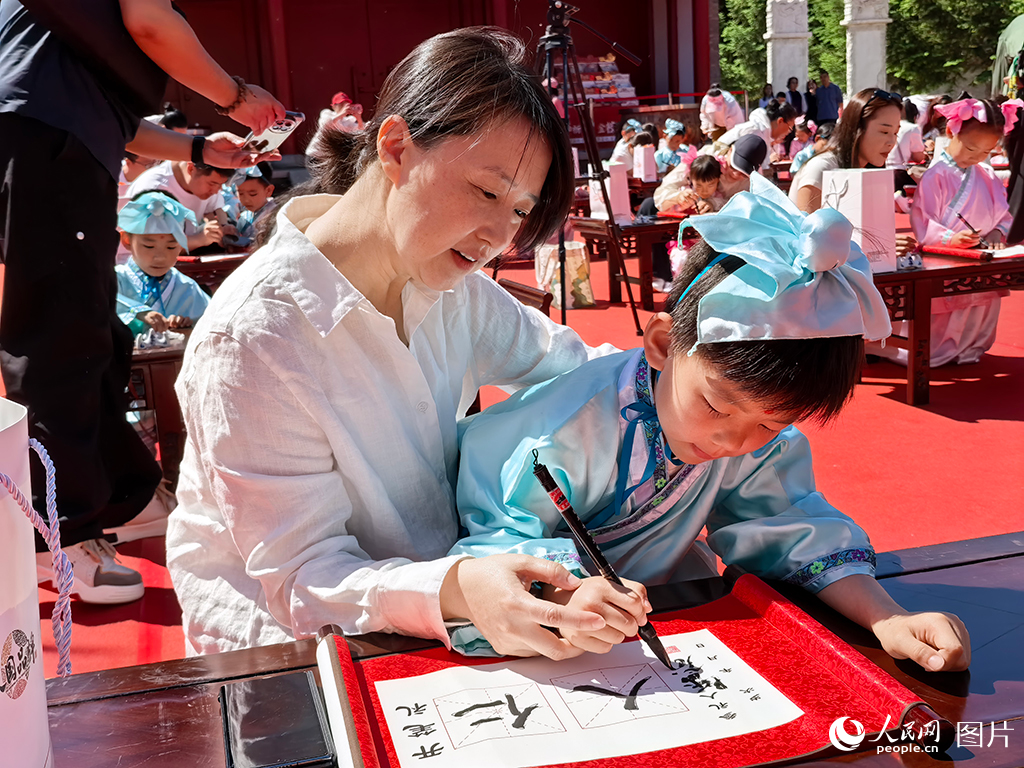 2026年5月30日，在吉林長(zhǎng)春文廟博物館傳統(tǒng)啟蒙禮活動(dòng)現(xiàn)場(chǎng)，孩子們提筆書(shū)寫(xiě)“仁”與“人”，在古韻雅樂(lè)中篤學(xué)明禮，開(kāi)啟嶄新的成長(zhǎng)篇章。人民網(wǎng)記者 王帝元攝
